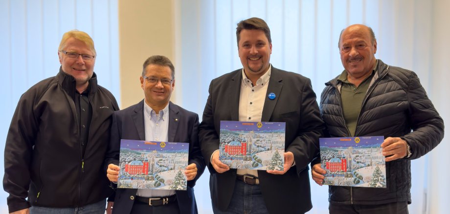 Künstler Josef Hawle, Bürgermeister Alexander Biber, Dr. Rolf Scheele, Präsident Lions Club Troisdorf und Jens Schäl, 1. Vizepräsident Lions Club Troisdorf präsentieren den Lions Club Kalender.