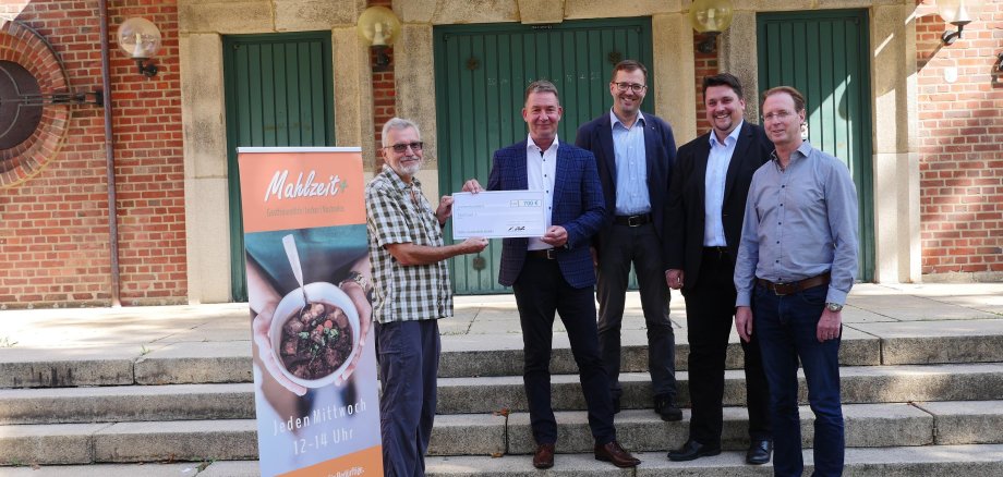 Frank Nelles (m.) vom Autohaus Nelles überreicht der Aktion"Mahlzeit+" einen Spendenscheck in Höhe von 700 Euro. v.l.n.r: Thomas Zumstrull (Vertreter des Ehrenamtlichen-Teams), Frank Nelles, Michael Lunkenheimer (Evang. Pfarrer), Bürgermeister Alexander Biber, Klaus Ersfeld (Diakon kath. Kirche)