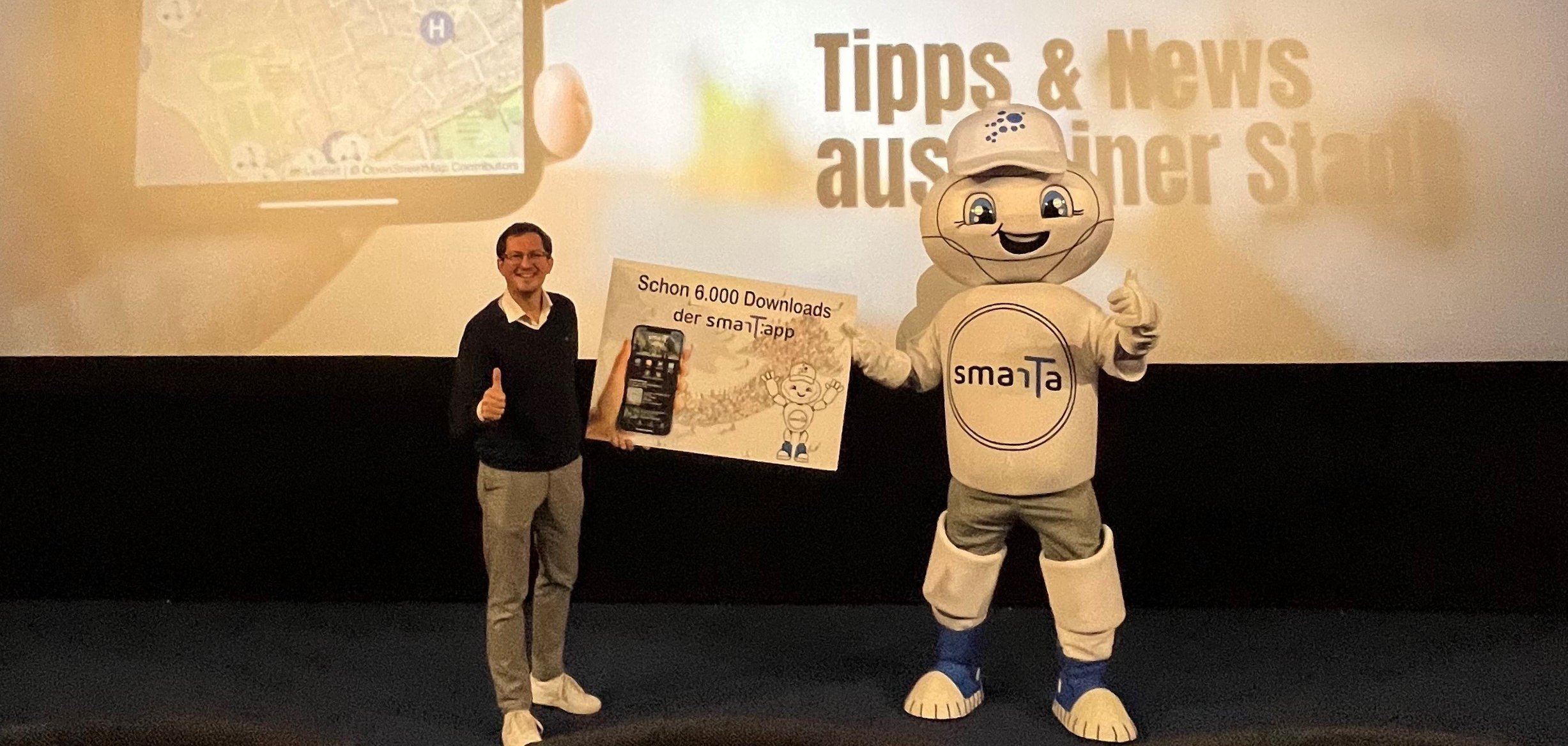 Max Schwerhoff, Projektkoordinator und Smart City Maskottchen Smarta machten sich ein Bild vor Ort im Kino Cineplex