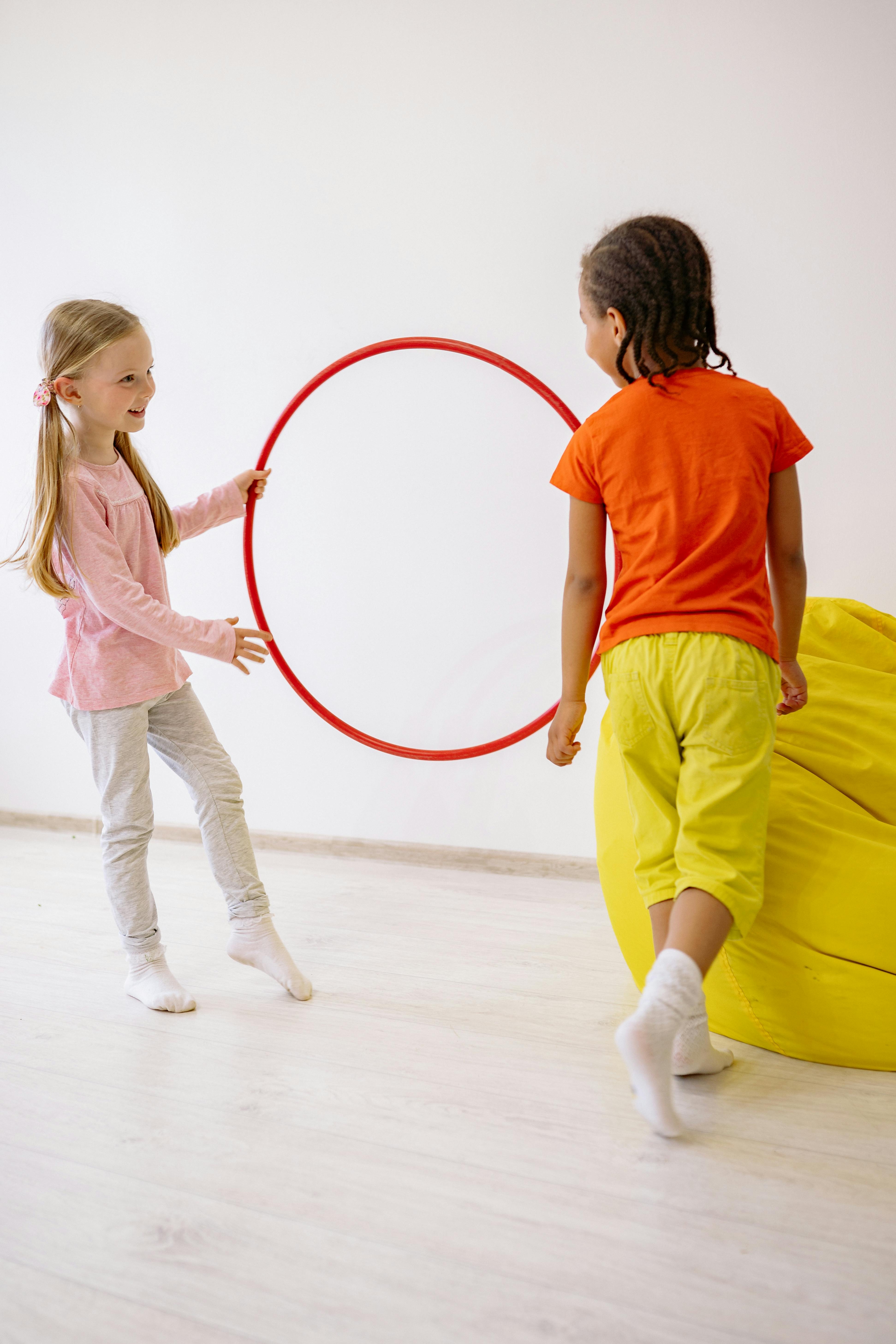 Zwei Kinder mit Hula Hoop- Reifen