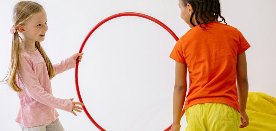 Zwei Kinder mit Hula Hoop- Reifen