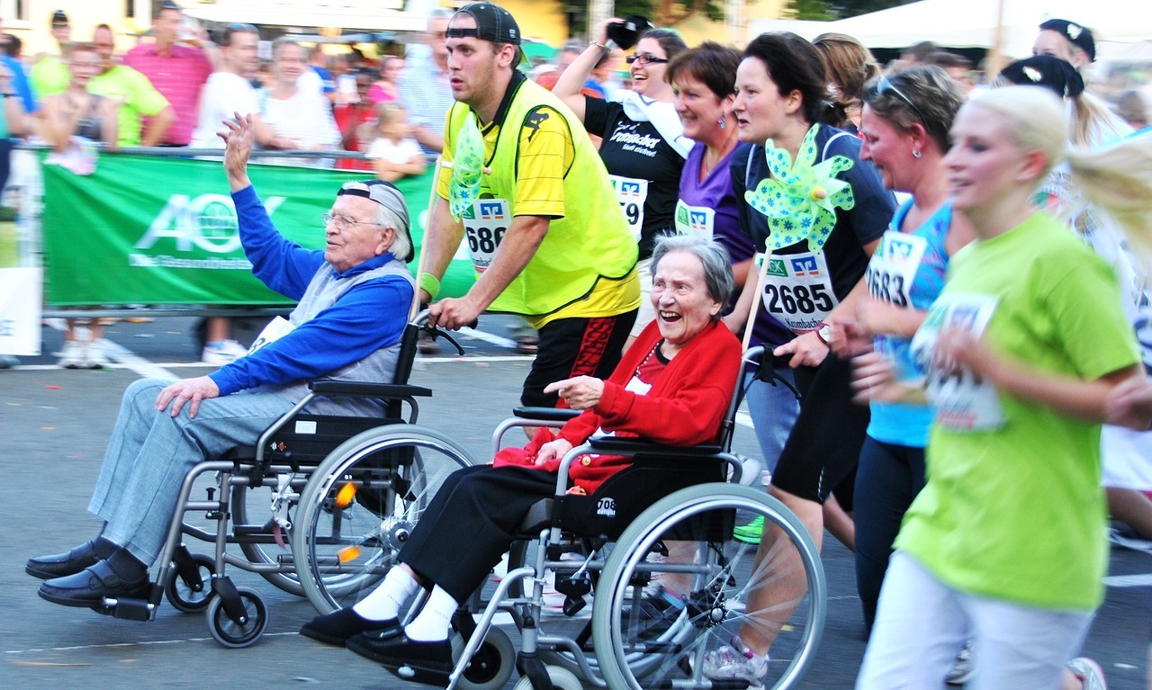 Zwei Senior*innen im Rollstuhl bei einem Lauf