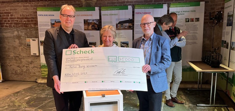 Einen Scheck in Höhe von 75.000 Euro überreicht Jörg Bambeck (l.) an Ulrike Tesch und Claus Chrispeels vom Heimat-und Geschichtsverein Troisdorf