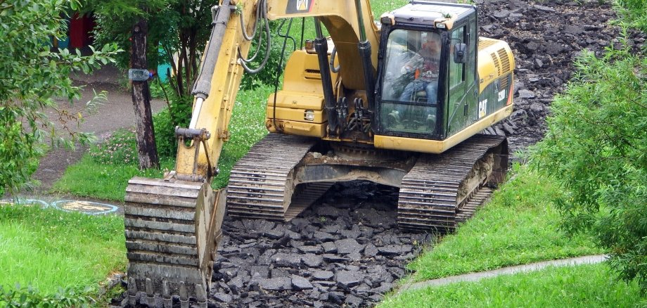 Bagger bricht Gehweg auf