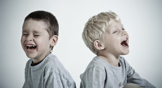 Schwarz-weiß-Foto: Zwei Kinder sind glücklich, sitzen entgegensetzt