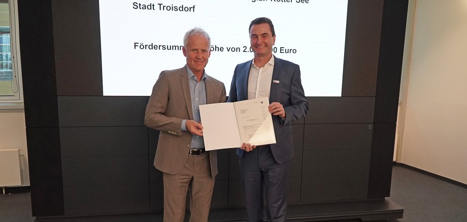 Der technische Beigeordnete der Stadt Troisdorf, Walter Schaaf (links) , bei der Übergabe des  Bewilligungsbescheides  durch Regierungspräsident Thomas Wilk in Köln 