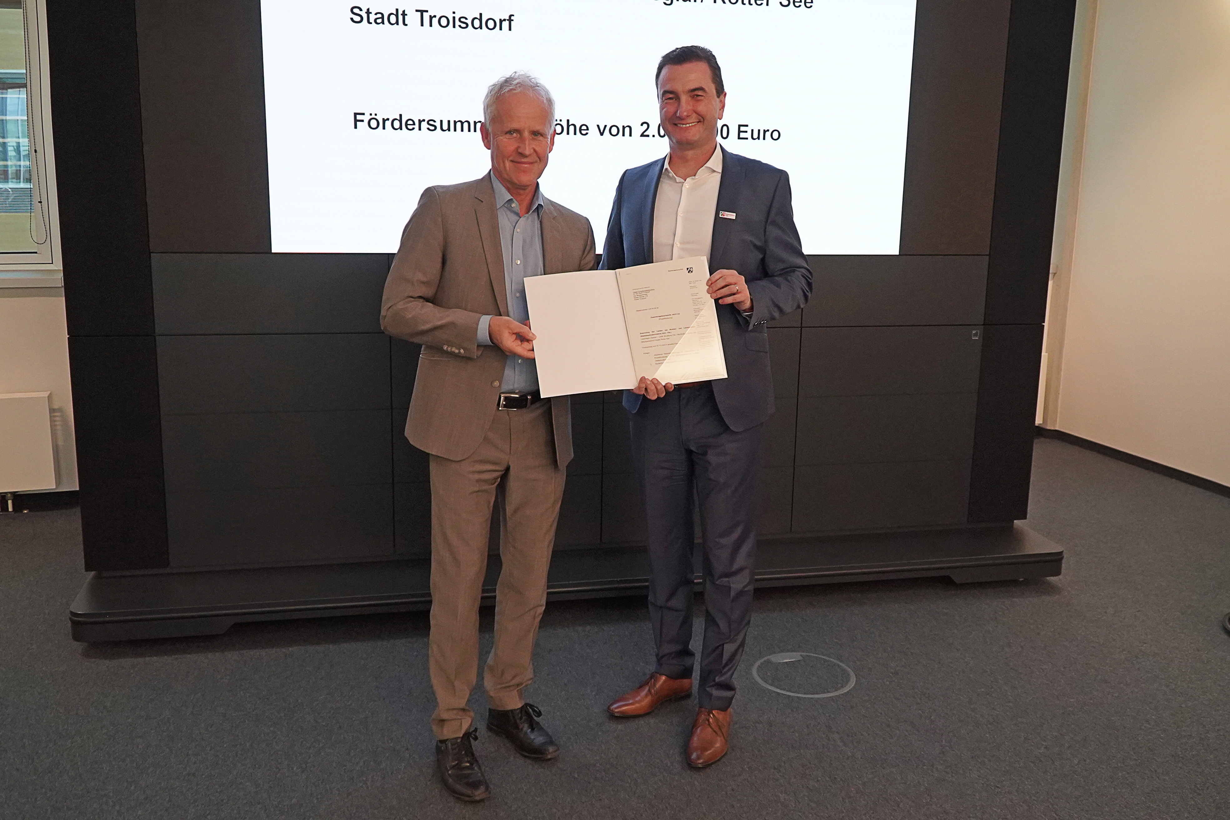 Der technische Beigeordnete der Stadt Troisdorf, Walter Schaaf (links) , bei der Übergabe des  Bewilligungsbescheides  durch Regierungspräsident Thomas Wilk in Köln 