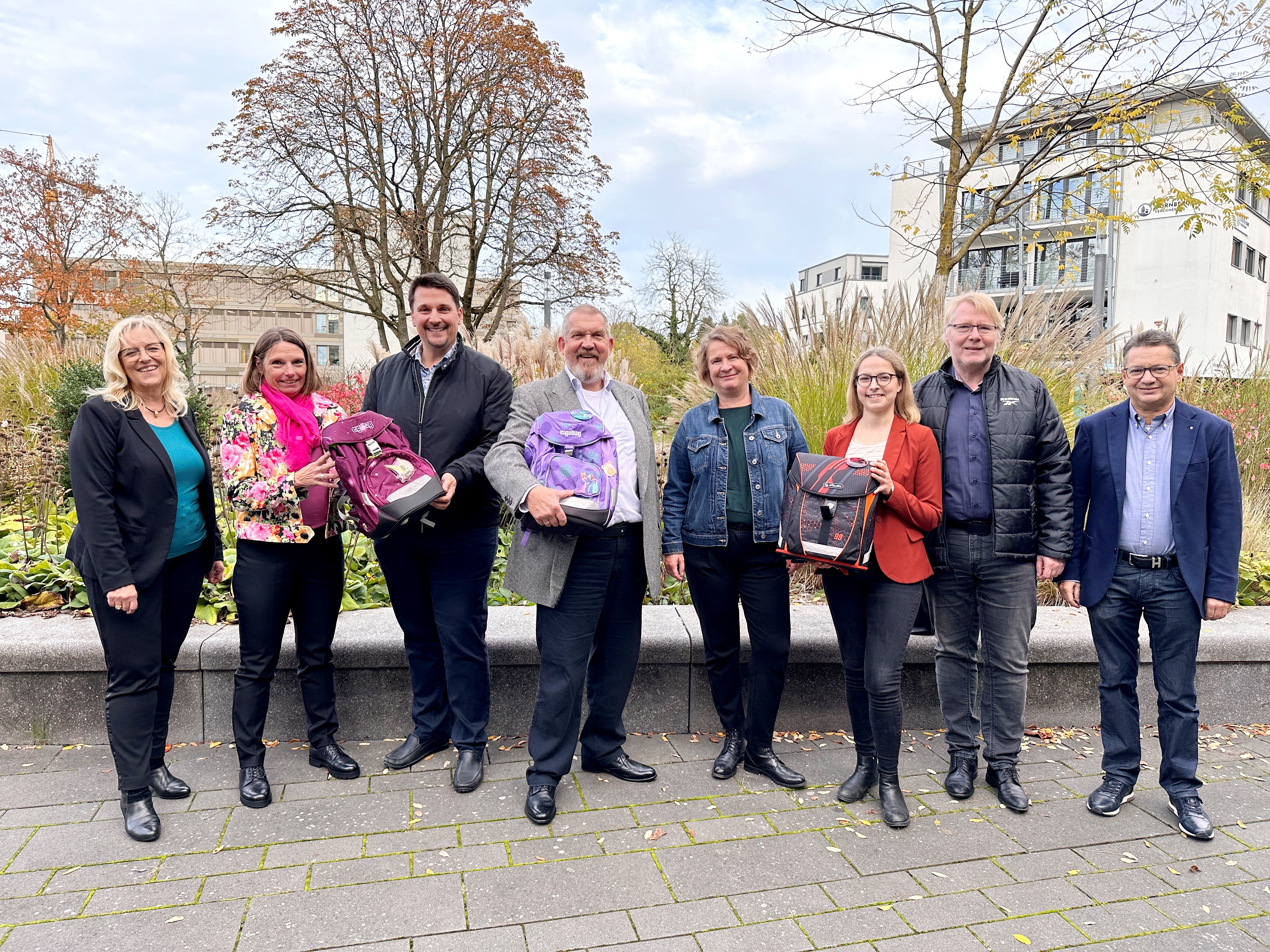 Bürgermeister Biber, "Tatort-Kommissar" Dietmar Bär (M) und Aktive der beteiligten Vereine präsentieren die Schulranzen-Aktion