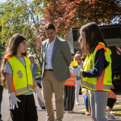 Gemeinsam mit Alexander Biber gestalten die Schulkinder die Wege von der Hol- und Bringzone zur Schule mit gelber Sprühfarbe („gelbe Füße“) und bunter Kreide.