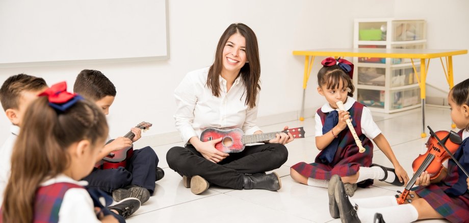 Junge Frau inmitten musizierender Kinder