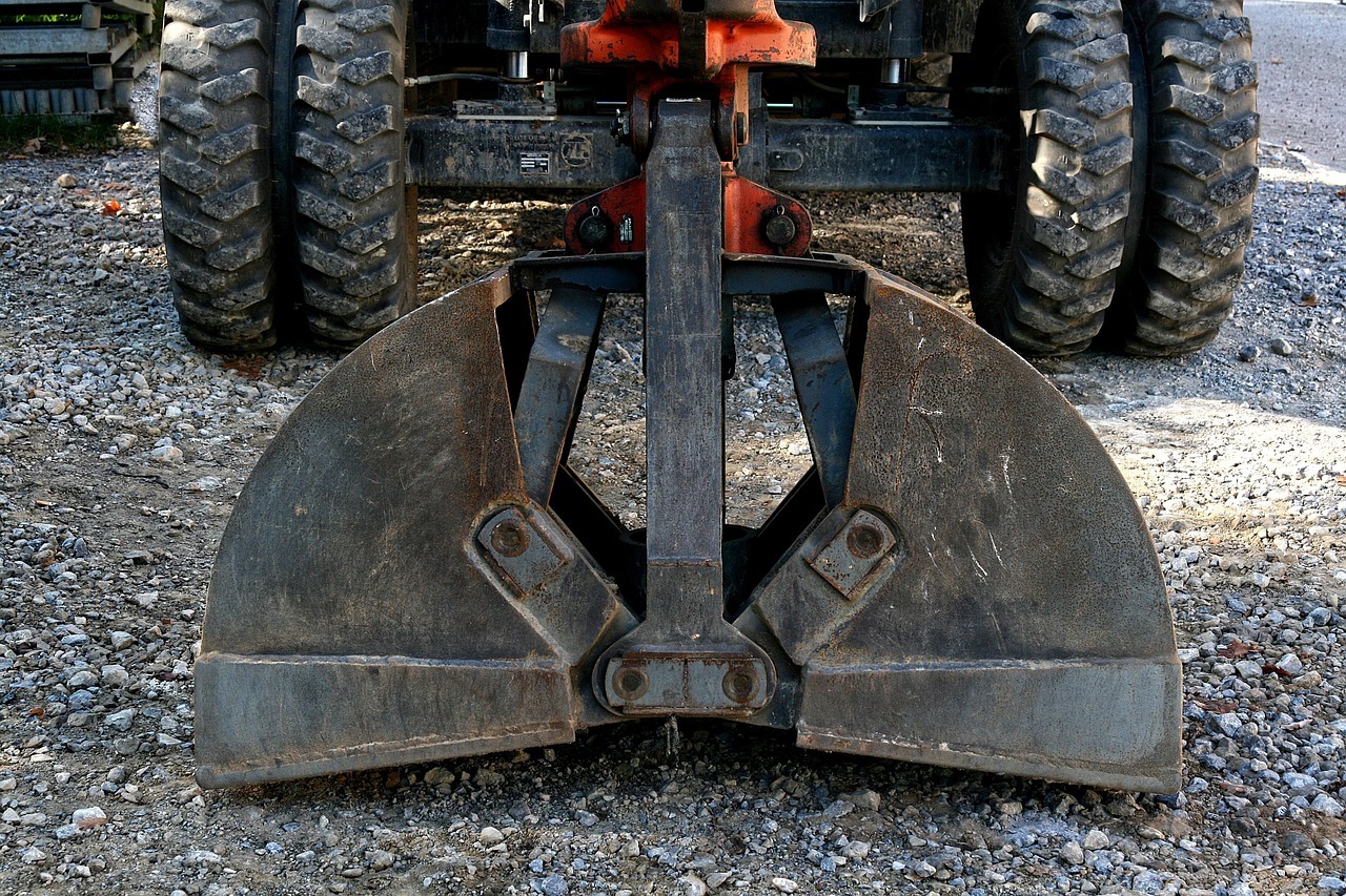 Baggerschaufel berührt Asphalt