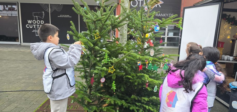 Kinder schmücken den Weihnachtsbaum