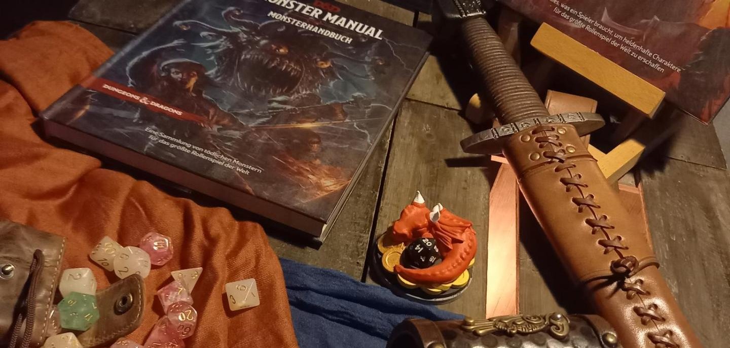 Das Bild zeigt Dungeons & Dragons-Spielmaterial: Bücher, Würfel, ein Schwert, Armschienen und eine Drachenfigur.