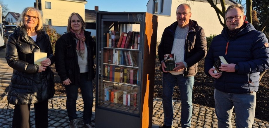 Freuen sich über die die kleine Bibliothek an der neuen Grünflache: v.l. Bücherschrank-Patin Hanne Brohl, Kerstin Kuffner vom Amt für Grünplanung, Ortsvorsteher Wolfgang Weithe-Berchtold und der Vorsitzende des Ortsrings Müllekoven Frank Peukert