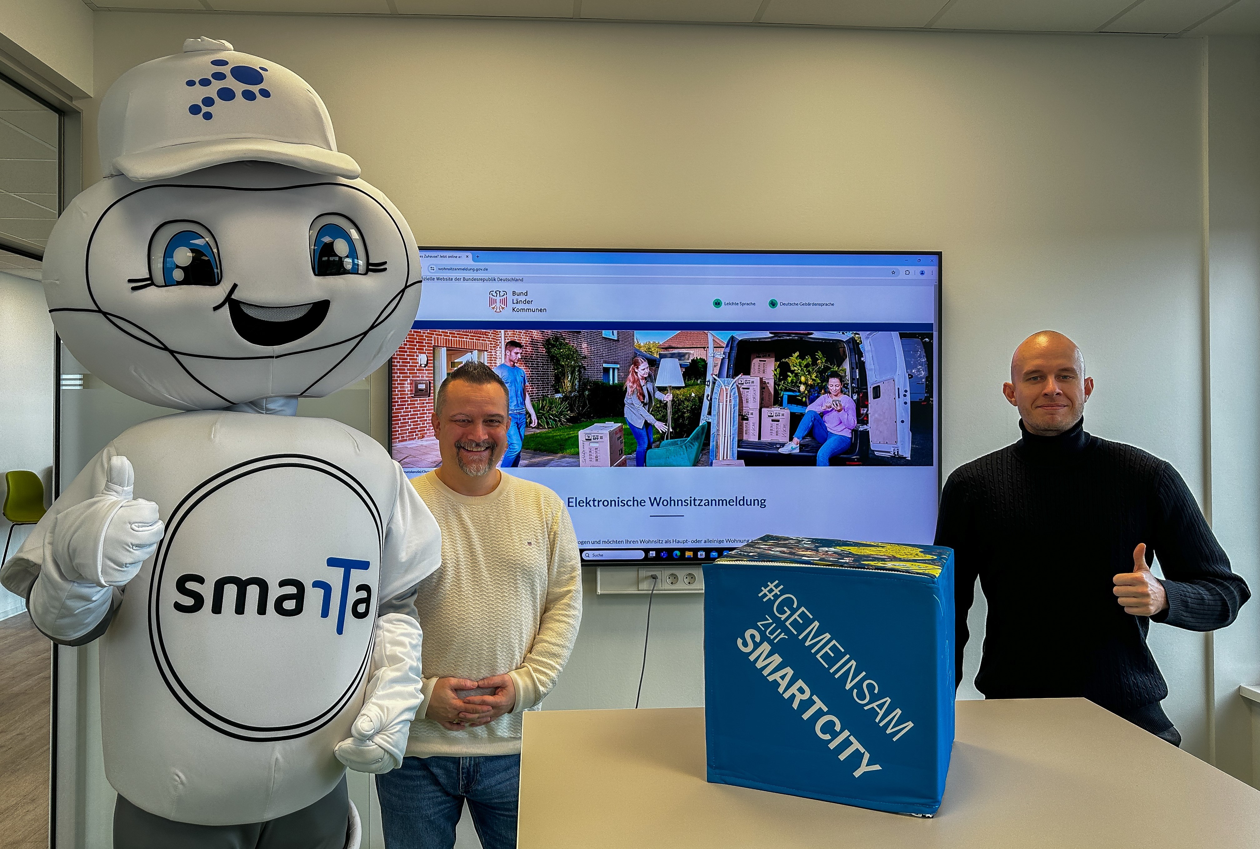 Smart City Maskottchen smarTa, Jan Masemann (Amtsleiter Standes- und Bürgeramt), Sebastian Glees (Projektleiter)