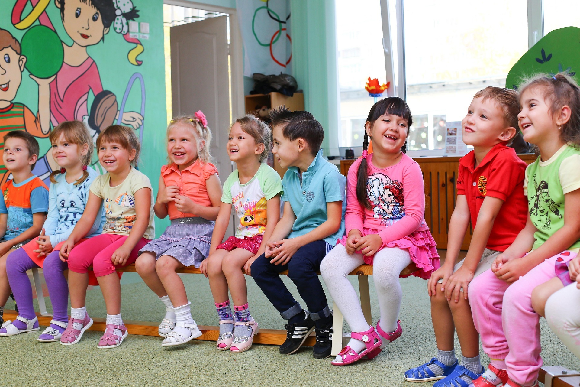 Kinder sitzen nebeneinander in der Kita