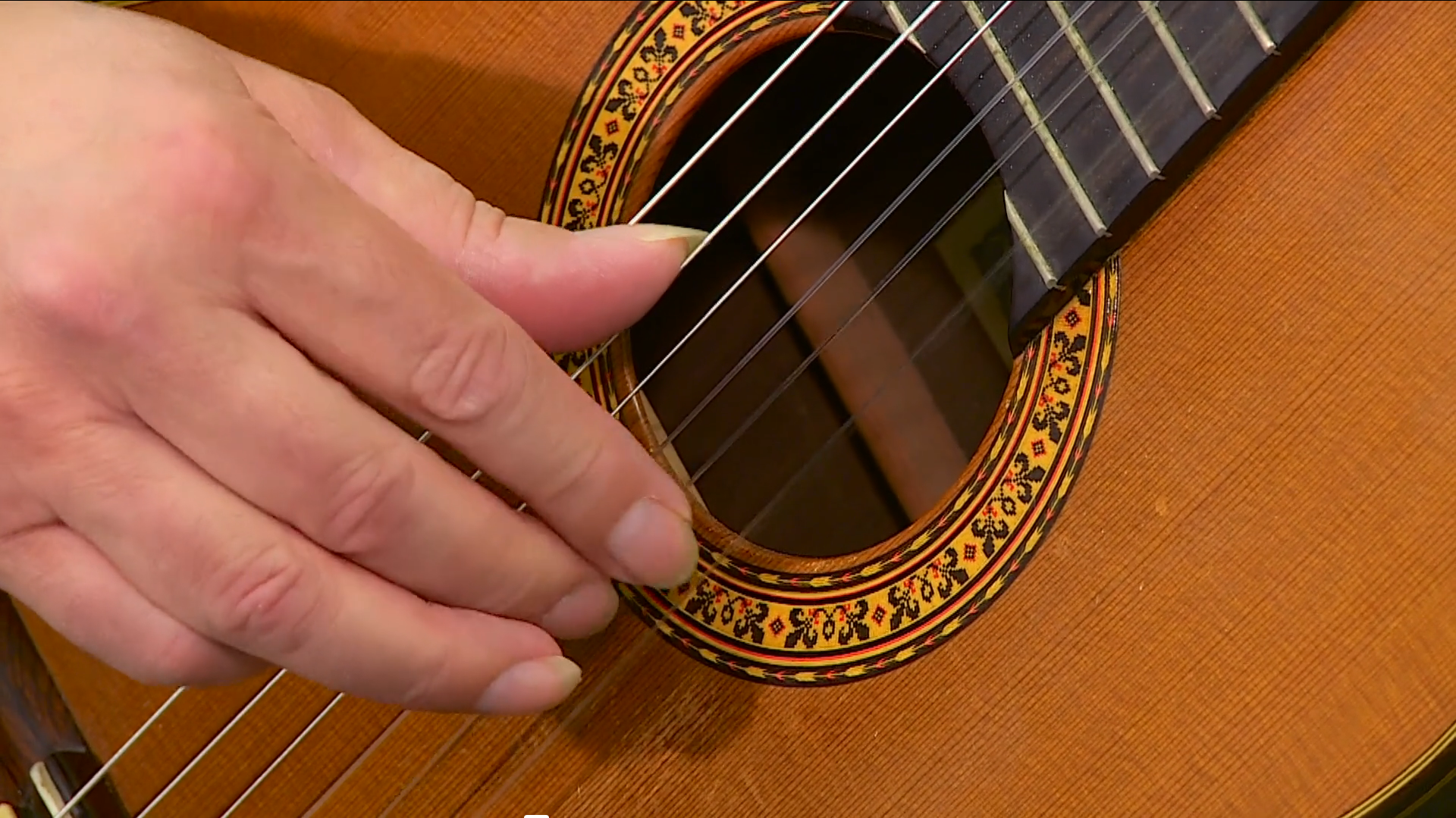 Eine Hand an einer Akkustik-Gitarre