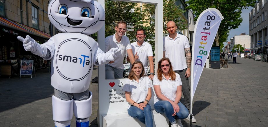 Smarta und die Mitarbeiter*innen der Stabsstelle Digitalisierung am Insta-Rahmen.
