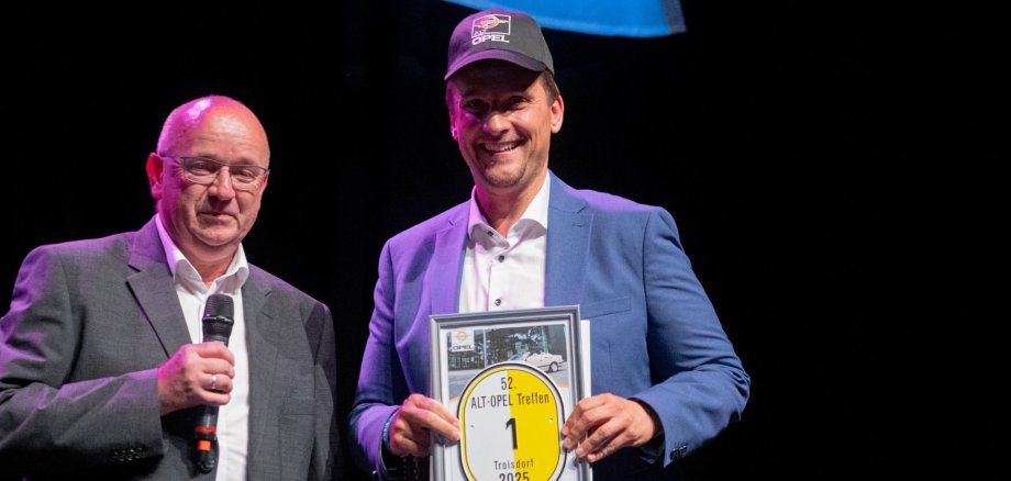 Mann mit Mikrofon (Dieter Budke) und Bürgermeister Biber mit Kappe