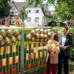 Bürgermeister Alexander Biber und die Erste Beigeordnete Tanja Gaspers warten vor dem Tor