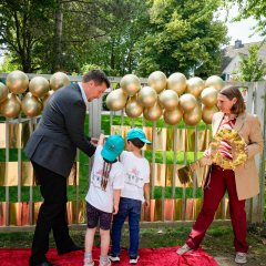 Bürgermeister Alexander Biber und die Erste Beigeordnete Tanja Gaspers mit Kindern vor dem Tor