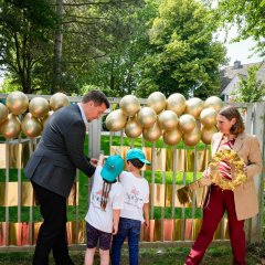 Bürgermeister Alexander Biber und die Erste Beigeordnete Tanja Gaspers mit Kindern vor dem Tor