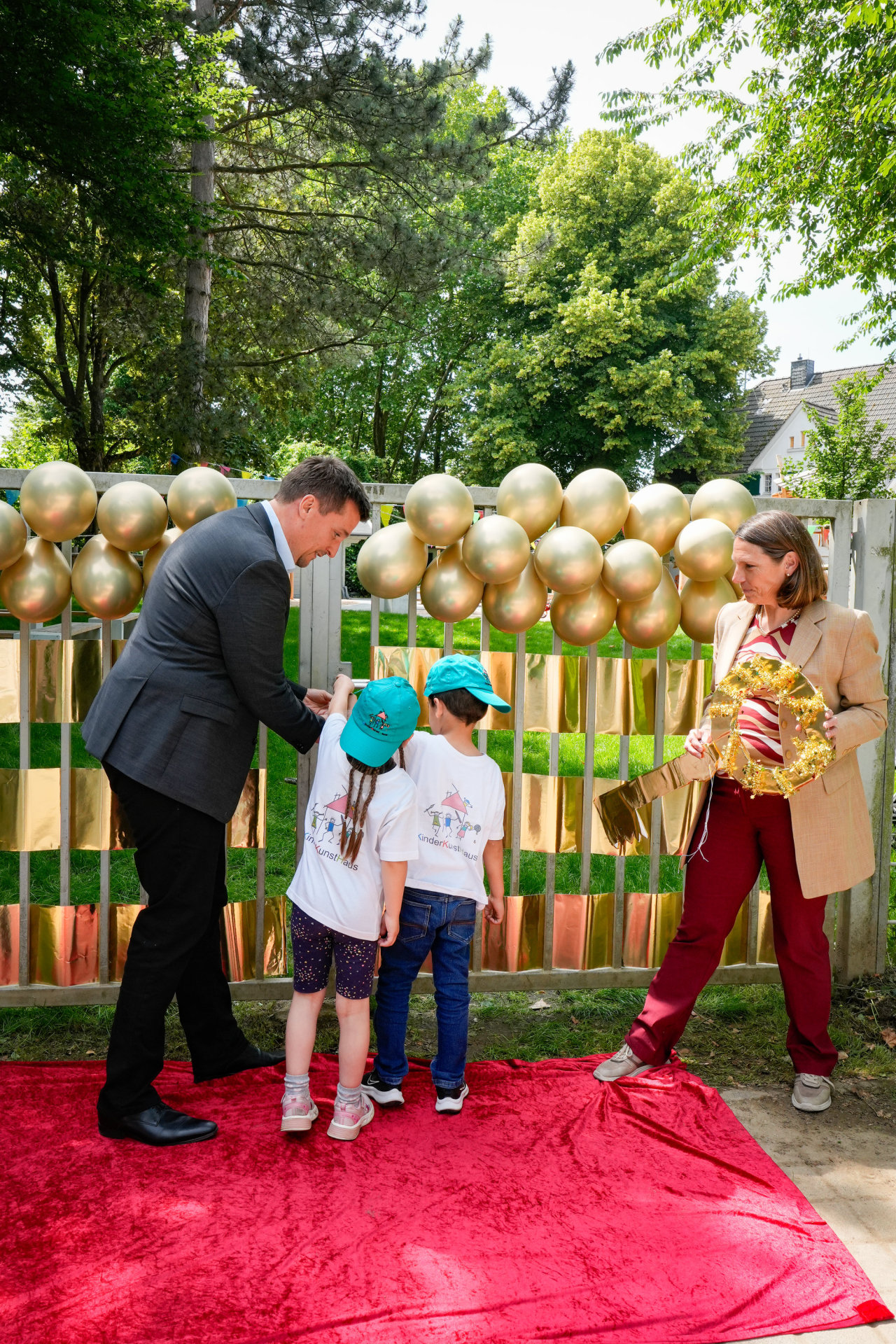 Bürgermeister Alexander Biber und die Erste Beigeordnete Tanja Gaspers mit Kindern vor dem Tor