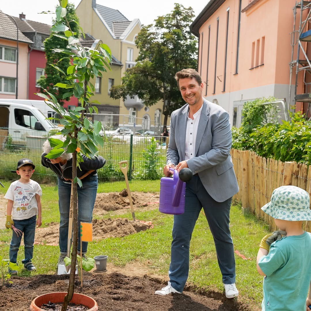 Bürgermeister Alexander Biber gießt einen Baum