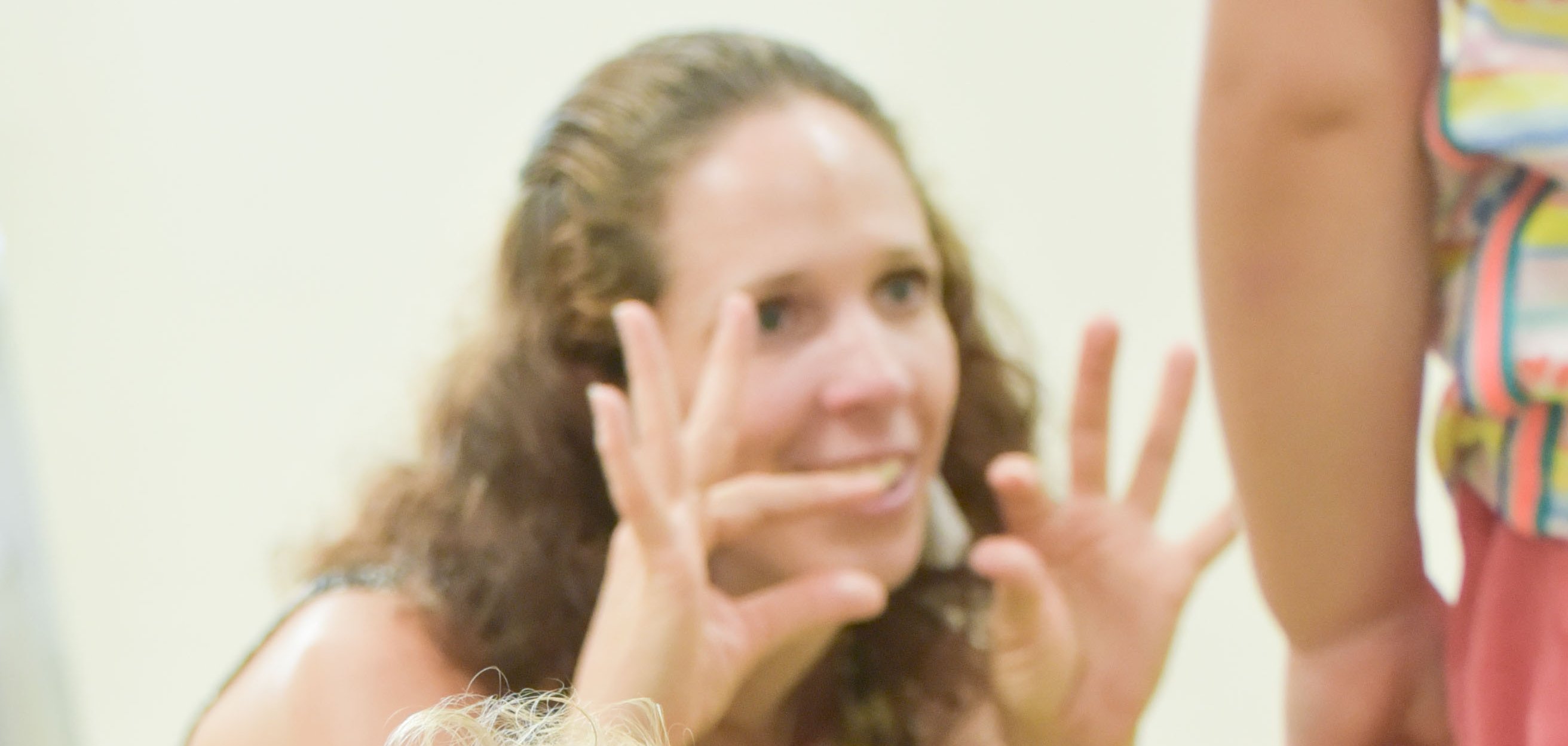 Ein Klindkind und eine Frau, die ein Zeichen macht.