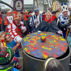 Der Prinz legt den Deckel auf den im Topf sitzenden Bürgermeister
