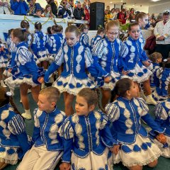 Blau-Weiß verkleidete Kinder führen ein Tanz im Foyer auf.