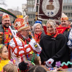 Der Prinz hält mit einem Mikrofon eine Rede vor dem Rathaus