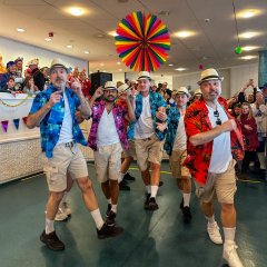 In Shorts und Hawaii-Hemd verkleidete führen eine Tanzaufführung vor