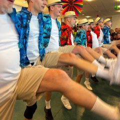 In Shorts und Hawaii-Hemd verkleidete führen eine Tanzaufführung vor