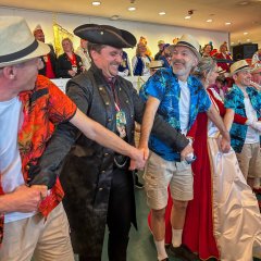 In Shorts und Hawaii-Hemd verkleidete führen eine Tanzaufführung vor und BM Herr Biber mittendrin