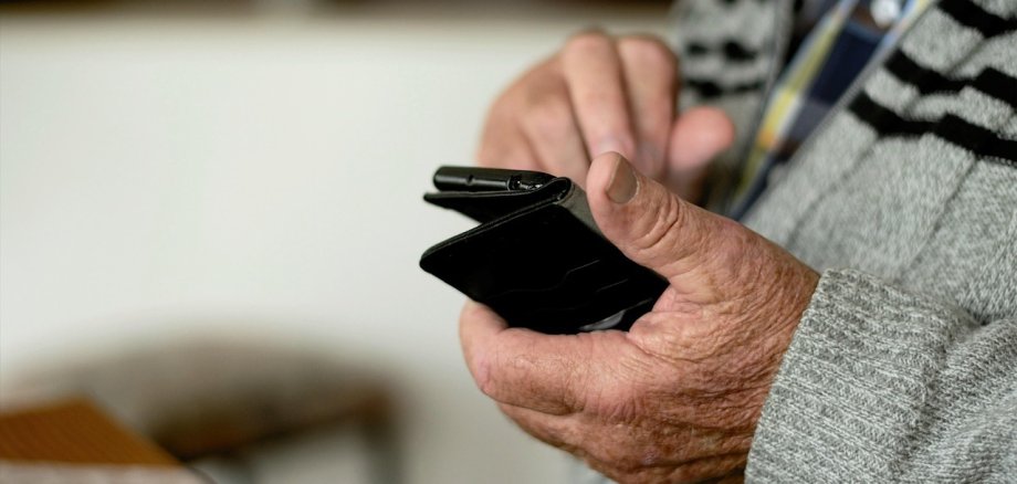 Ein älterer Mann bedient ein Smartphone