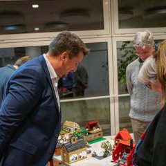 Bürgermeister Alexander Biber betrachtet die Bauwerke der LEGO-Gruppe im Gespräch mit den Teilnehmenden.