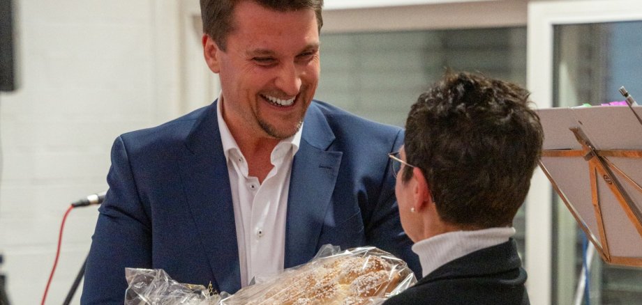 Bürgermeister Alexander Biber überreicht der Ansprechpartnerin für ZWAR Troisdorf Annette Kuhn ein Präsent