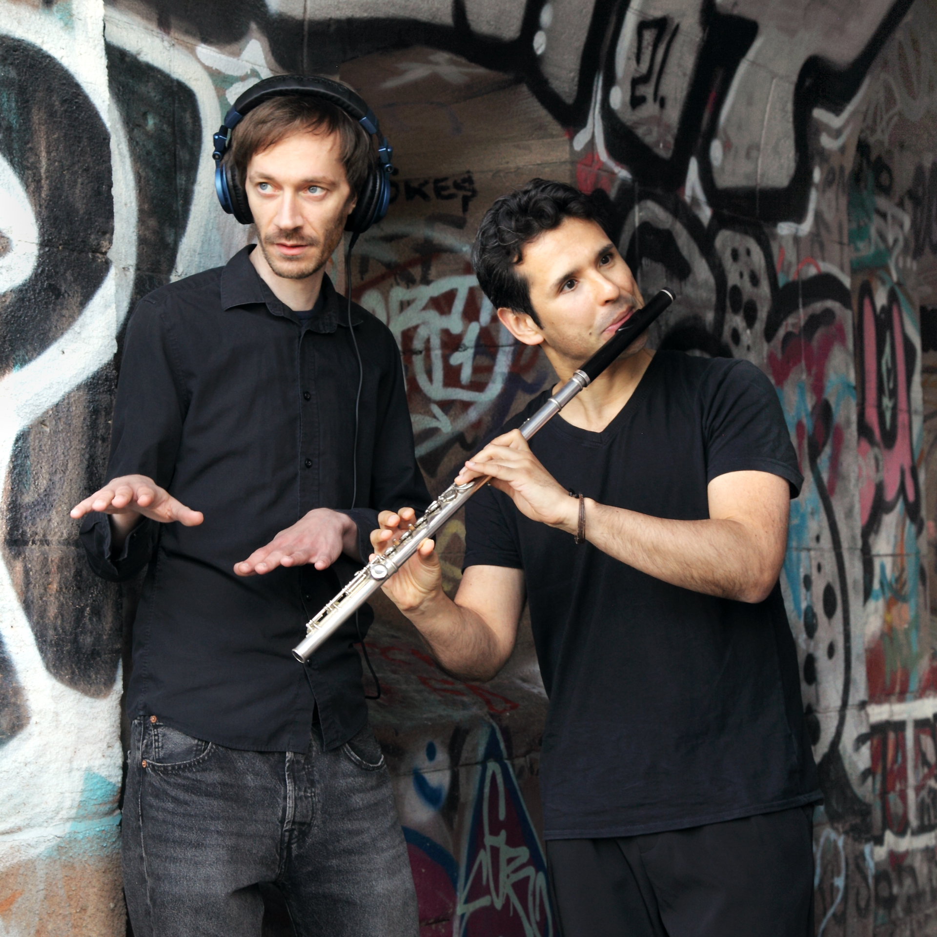 Zwei Musiker, einer mit Kopfhörer, der andere mit Flöte