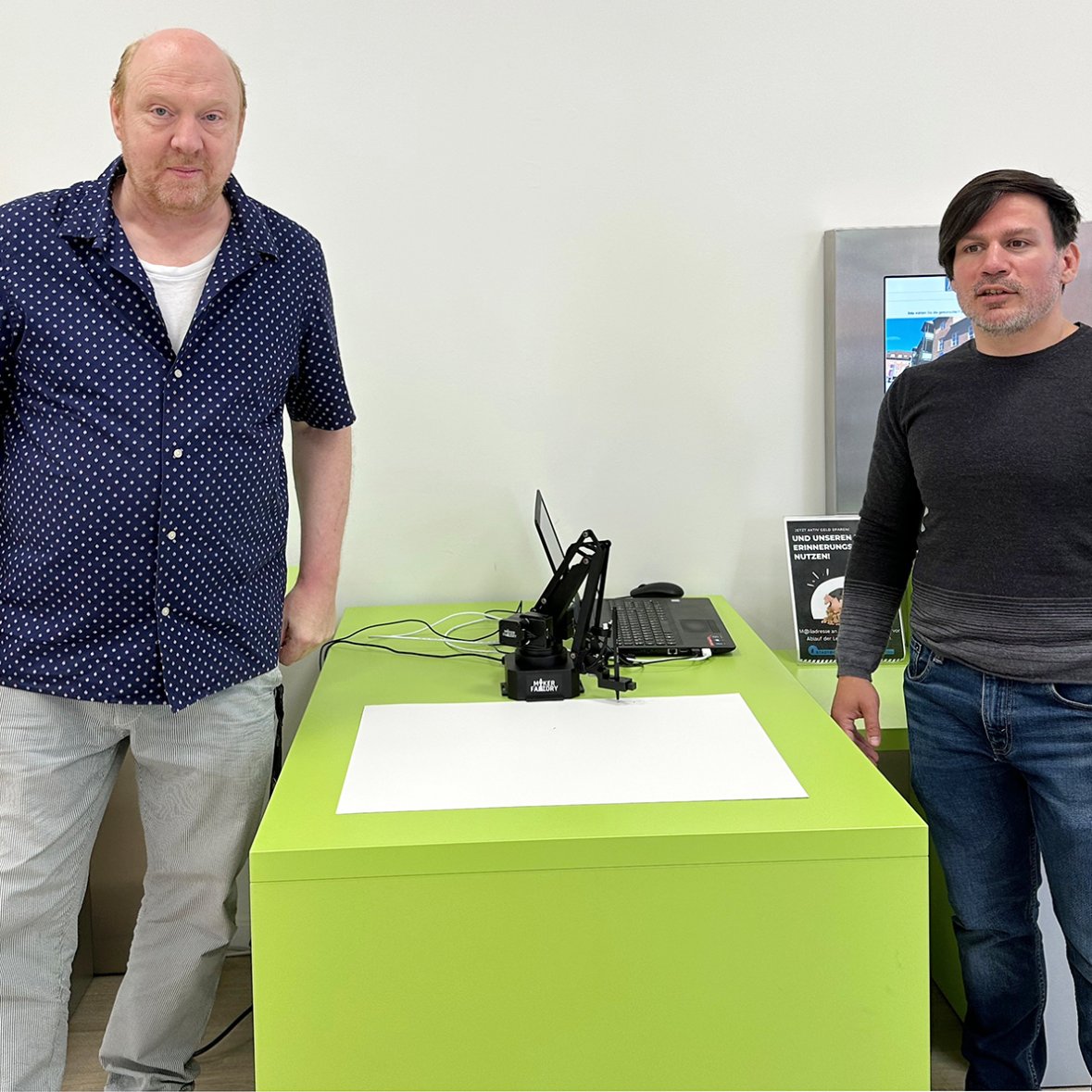Frank Baquet (Kunsthaus) und Philipp Maaß (Stadtbibliothek) mit dem KI- gesteuerten Zeichenroboter Üffes