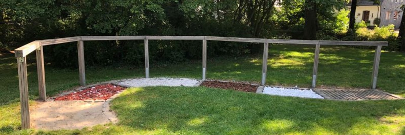 In verschiedene Bereiche unterteilter Barfusspfad mit Geländer