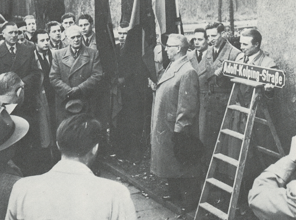 Vermutlich Einweihung der Adolf-Kolping-Straße durch den Lehrer Alois Müller im Jahre 1953 (Quelle: Karlheinz Ossendorf: Troisdorf, wie es einmal war, Neunkirchen-Seelscheid 1985, S. 86)