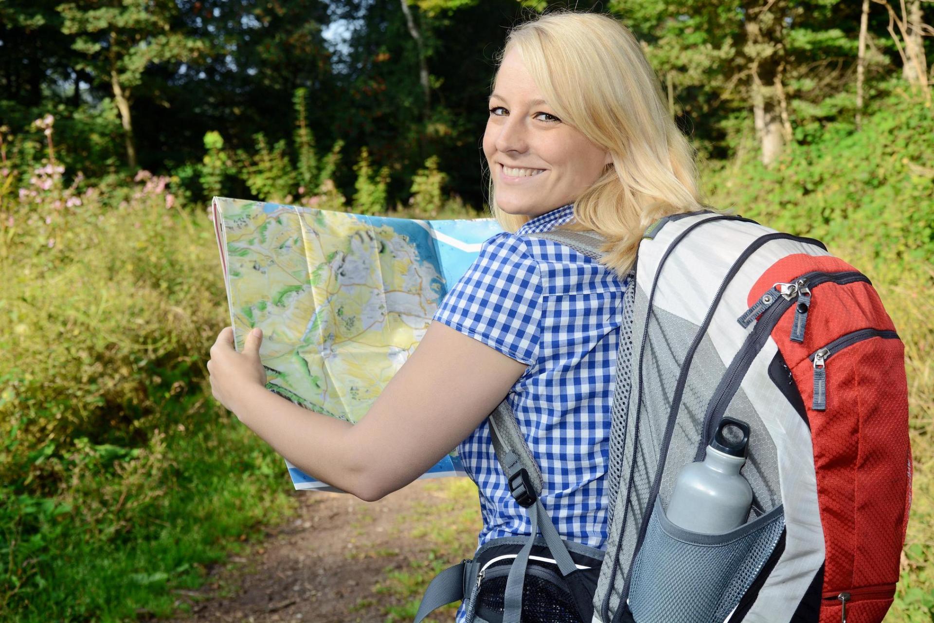 Frau beim Wandern mit Wegekarte